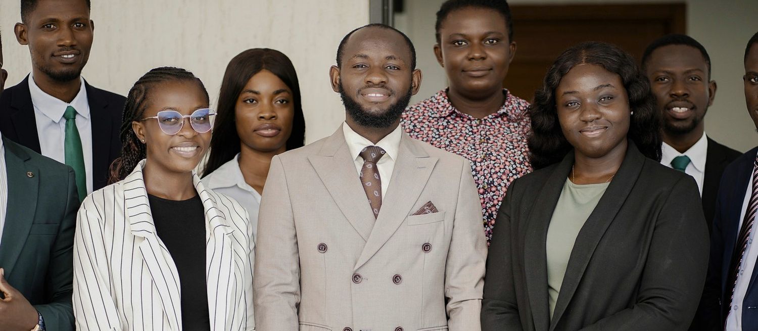 Colleagues at Elixir Audits standing together in business dress at the firm's office in Accra